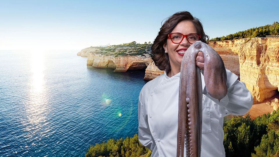 Panoramic photograph of a small part of the Algarve coast where, from left to right, the sea meets the rocks. On the right hand side, above the photograph, Chef Noélia Jerónimo is holding an octopus in her left hand that partially covers the lower part of her face.